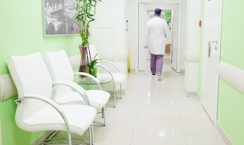 A doctor walks down a lime green hall
