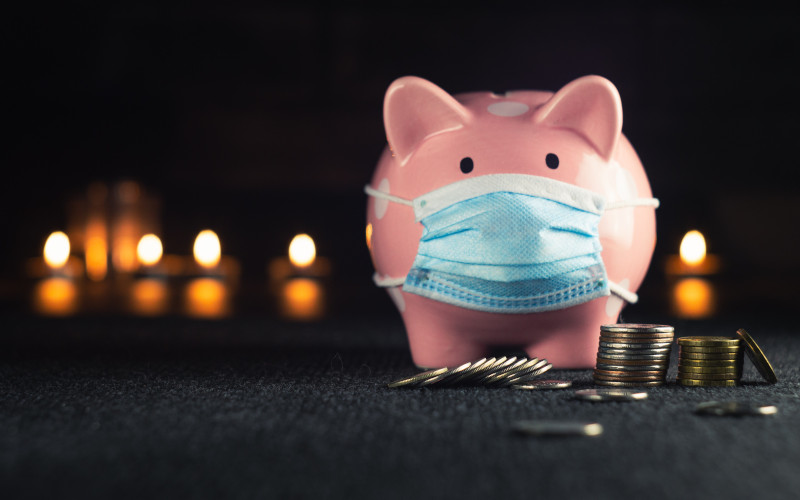 Pink piggy bank wearing a medical mask 