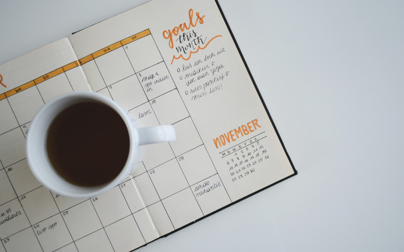 Cup of coffee sitting on a day planner.