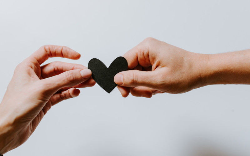 Two hands holding a paper heart