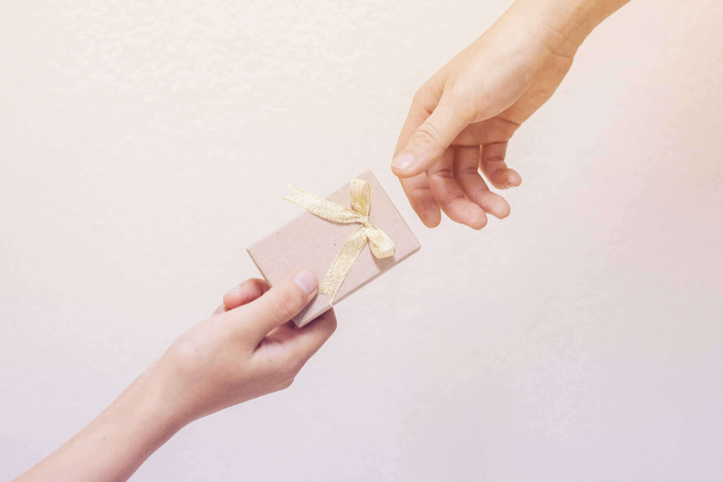 Two hands passing a gift from one to the other