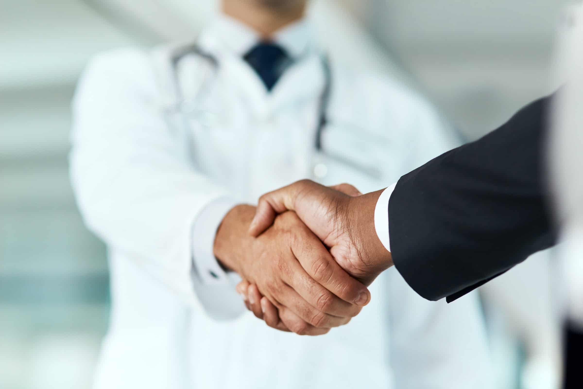 Doctor and businessperson shaking hands