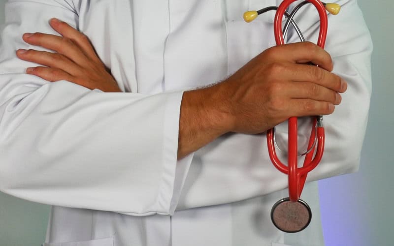 A doctor with arms crossed, holding a stethoscope