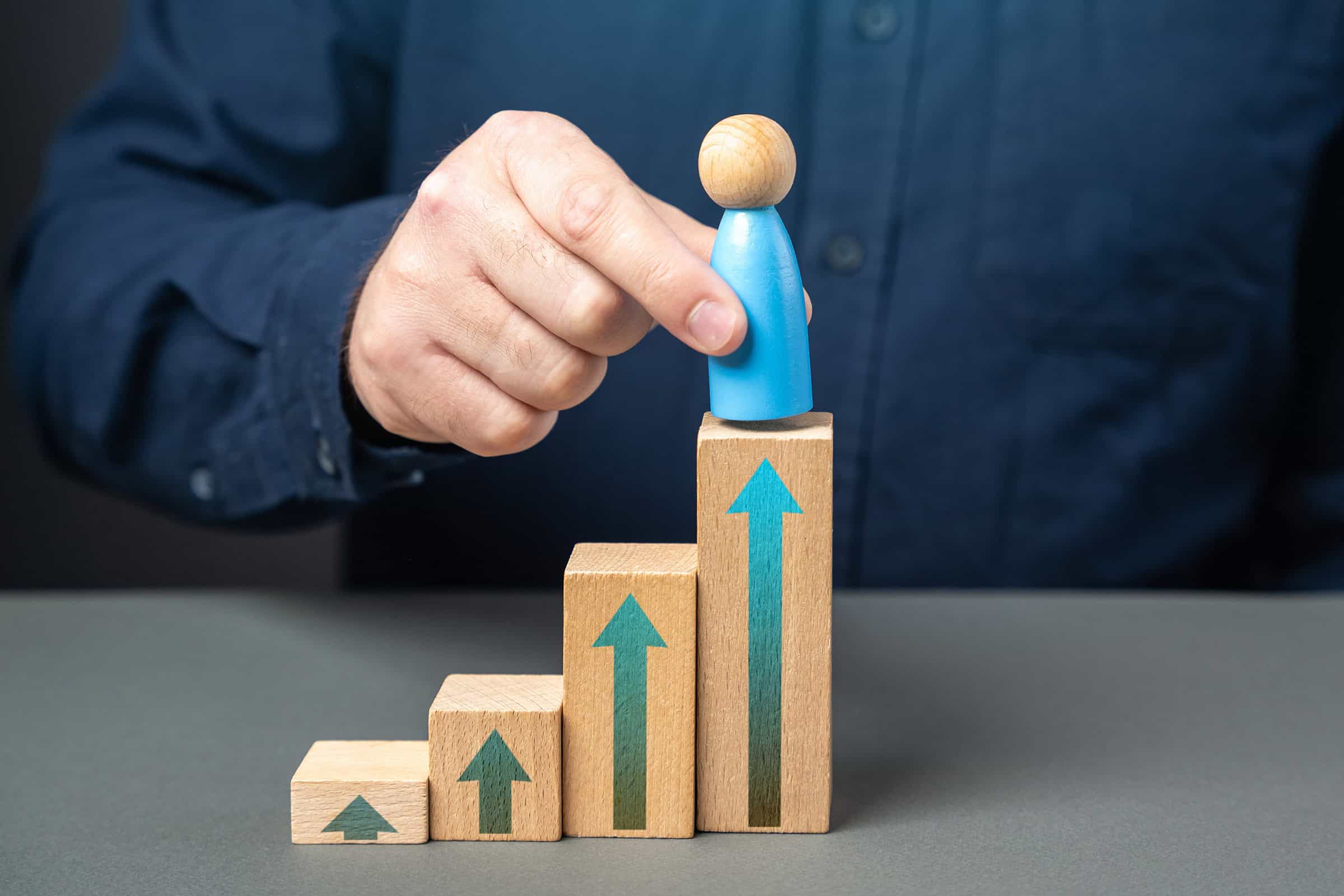 A man places a figurine of a man at the top of the stairs