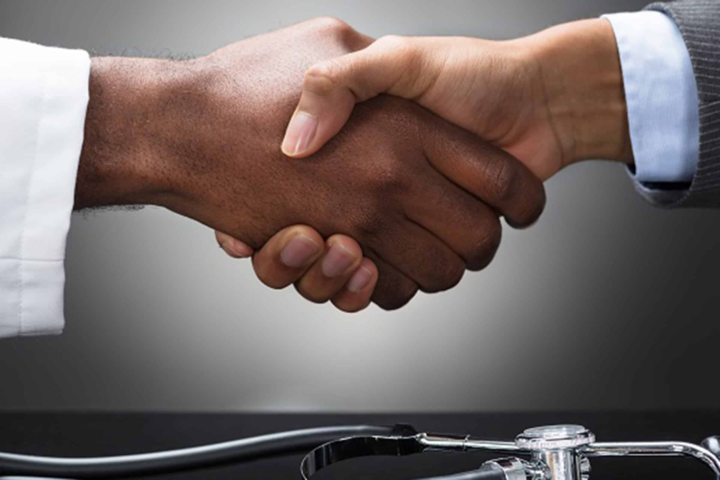Physician and businessman shaking hands