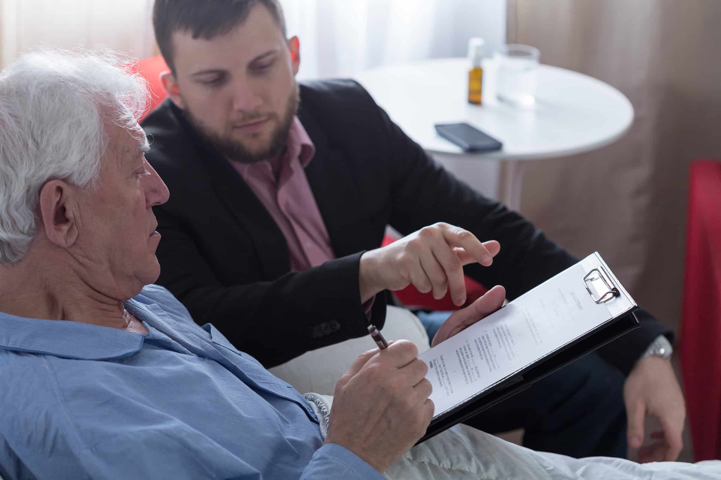 An older man and a younger man reviewing a contract together